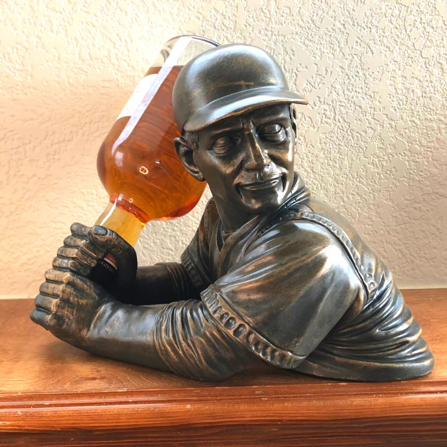 Batter Up Baseball Bottle Holder - In Use with whiskey bottle on mantle facing forward