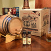 Custom Whiskey Bootleg Kit® - displaying whiskey barrel on stand with no design, whiskey essence, and box on table
