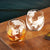 Etched World Continents Travelers Whiskey Tumbler Set- displayed on table, one with whiskey in it and one empty
