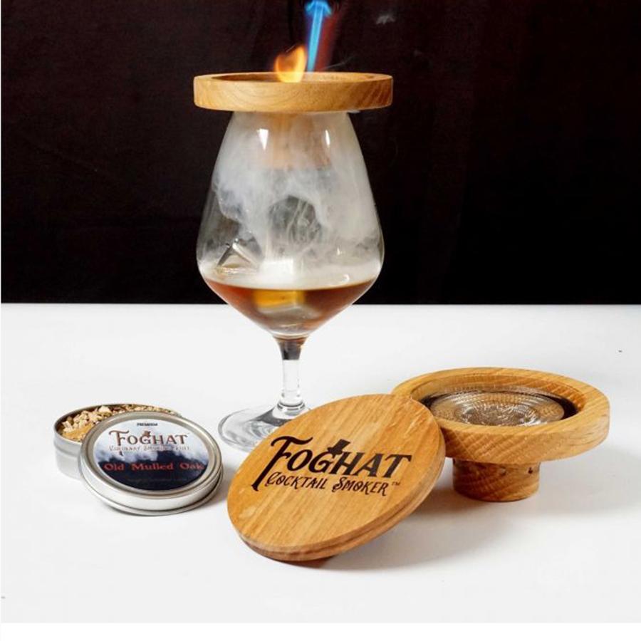 Foghat Cocktail Smoker displayed on table with whiskey glass having smoke in it