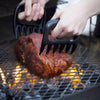 Jack Of All Trades Meat Multi-Use Tool in use picking meat up off of a charcoal grill